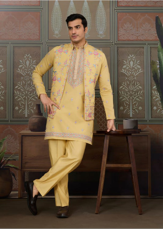Man wearing a yellow embroidered sherwani in a decorated room.