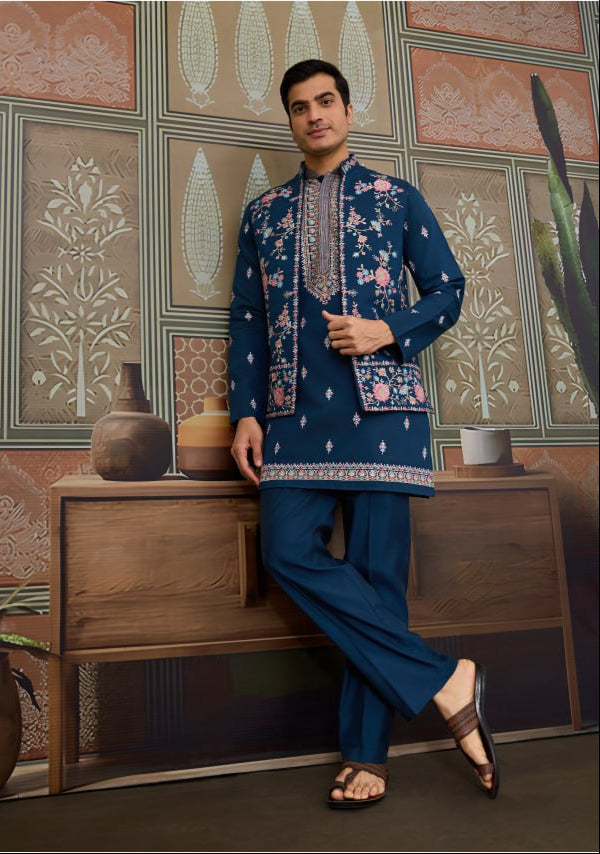 Man wearing a navy blue embroidered kurta with pants in an indoor setting.