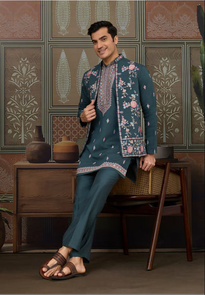 Man wearing a traditional outfit in a decorative room with patterned walls.