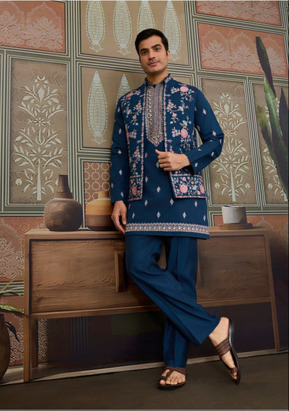 Man wearing a navy blue embroidered kurta with pants in an indoor setting.