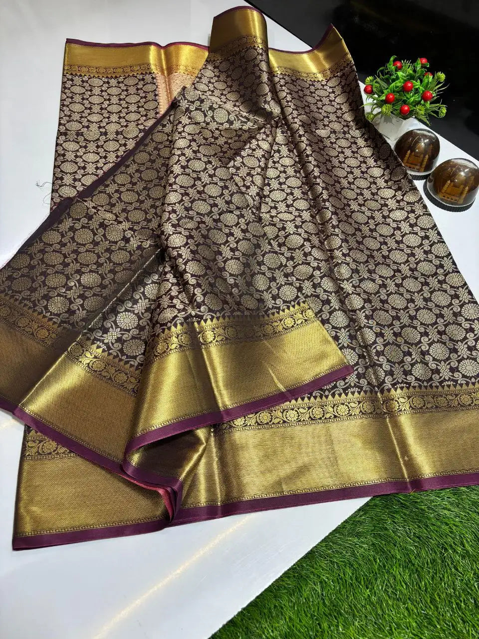 Close-up of pure zari border and zari woven work on wine Banarasi silk saree

